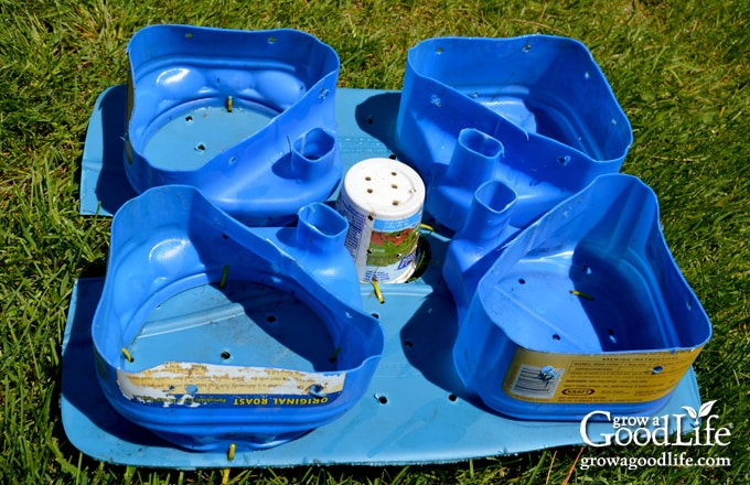 Recycled coffee containers cut in half and attached as sturdy supports for the aeration shelf.