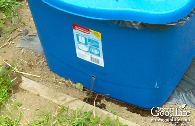 Water being poured into the fill tube of a self-watering planter.