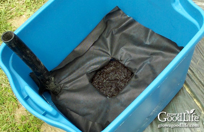 Pre-moistened potting mix packed into the wicking basket of a self-watering planter.