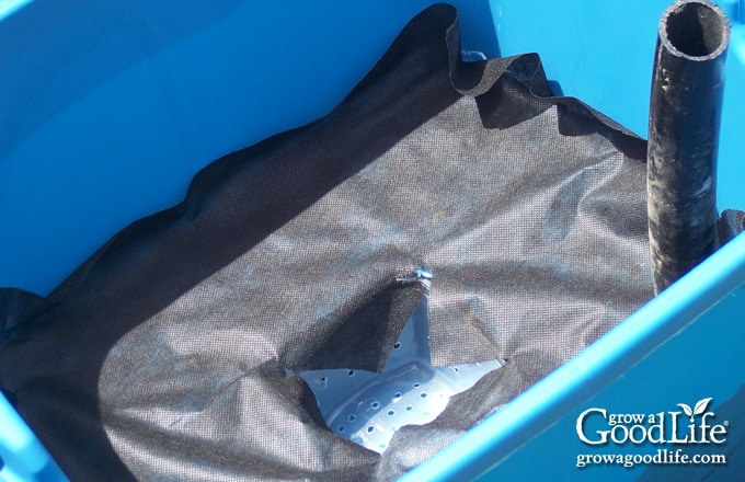 Landscape fabric covering the aeration shelf inside a self-watering planter.