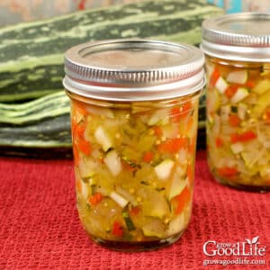 Jars of home canned zucchini relish on a table.