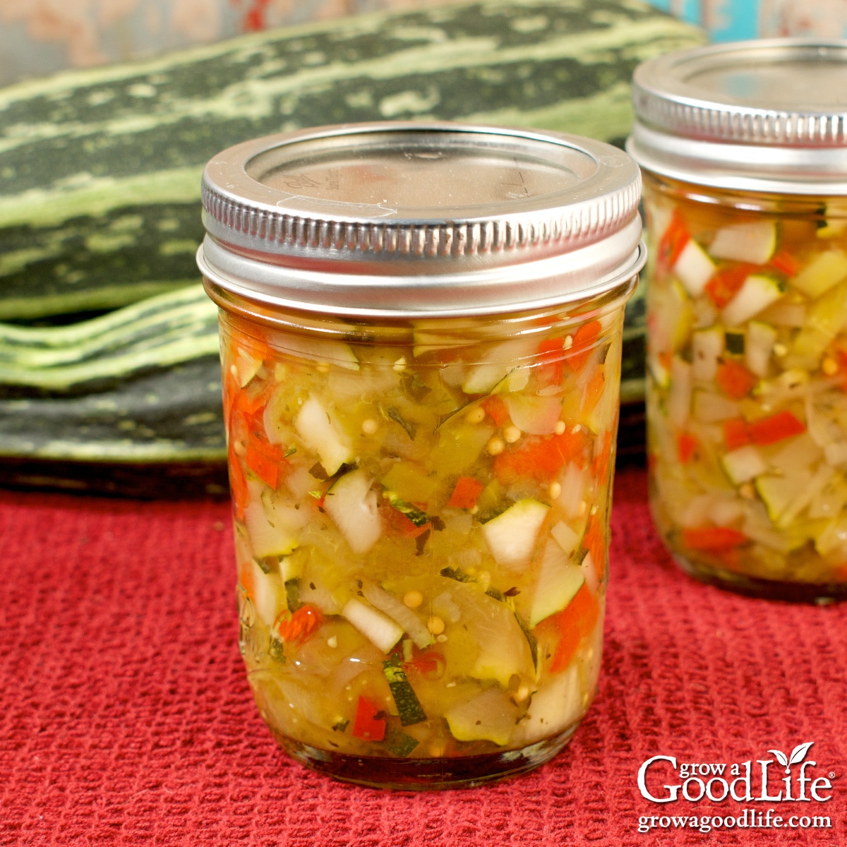 Jars of home canned zucchini relish on a table.