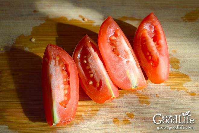 quartered tomatoes on a cutting board