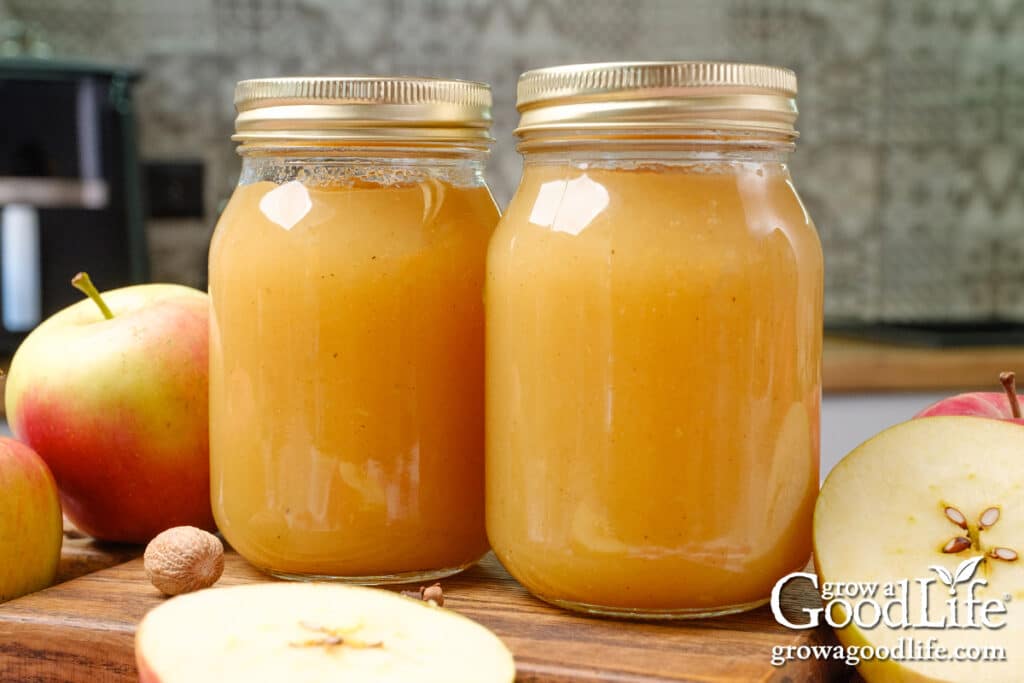 Jars of home canned applesauce on a table.