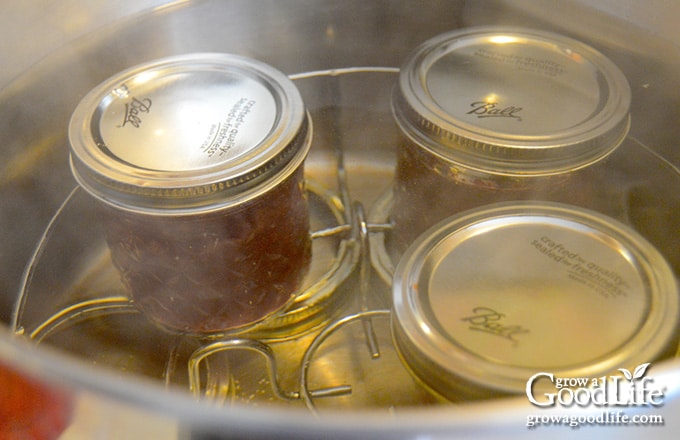 three jars of jelly in a water bath canner