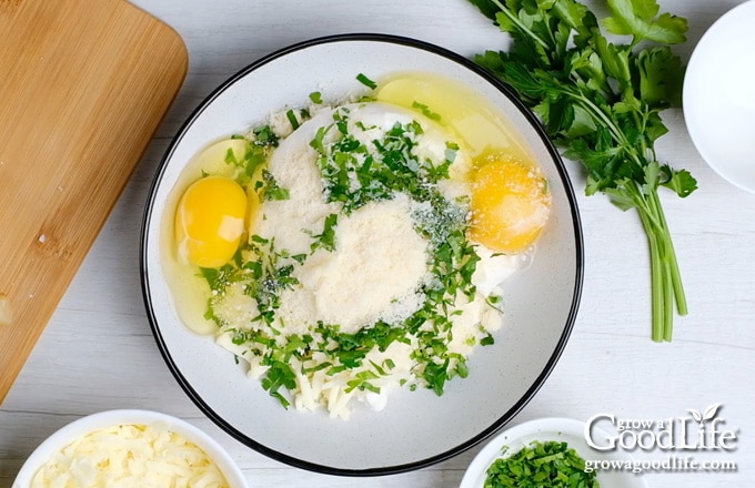 combining the ricotta, Parmesan, Mozzarella, egg, and parsley in a bowl