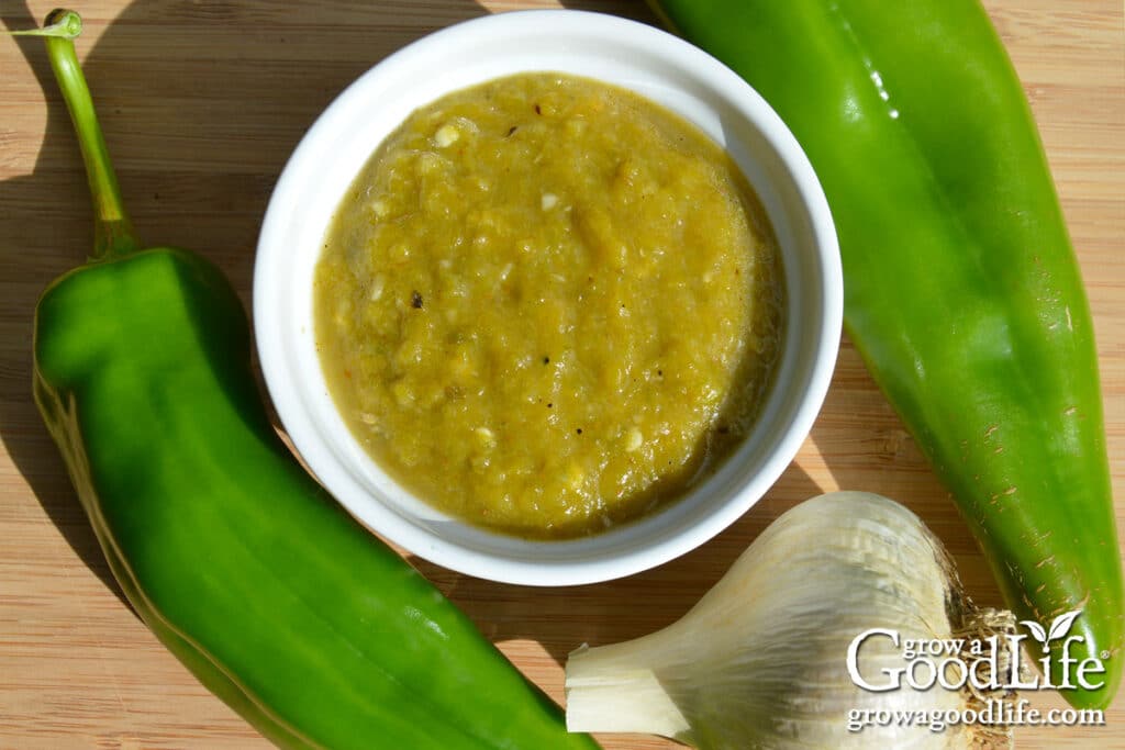 Over head view of a bowl of roasted green chile sauce on a table.