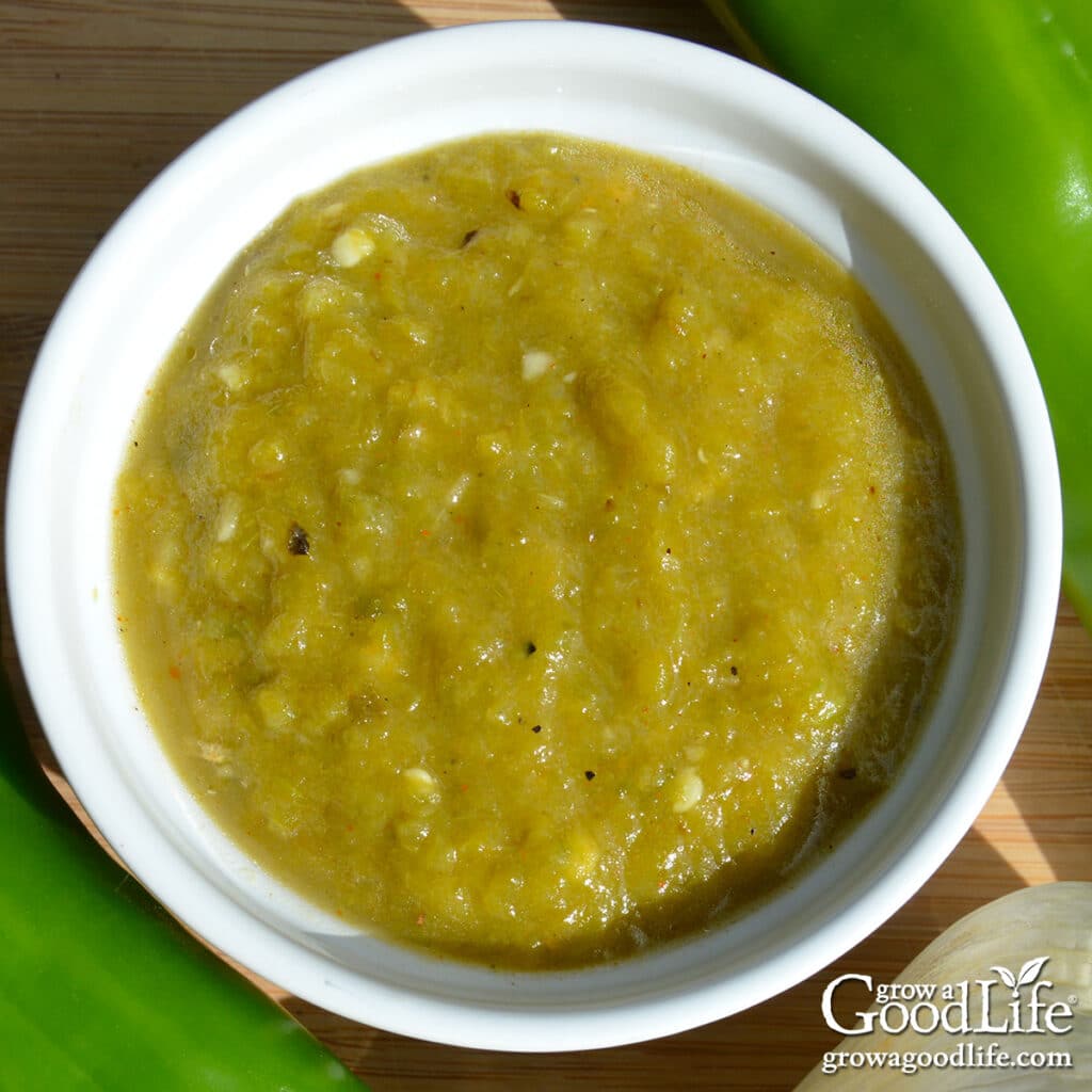 A bowl of roasted green chile sauce on a table.