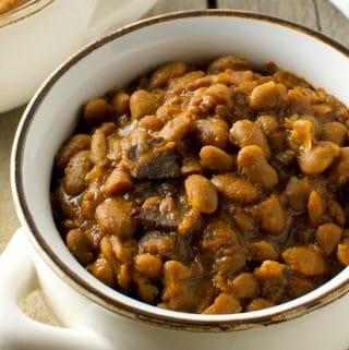 With a few simple ingredients and time, you can make a delicious, slow cooked New England baked beans dinner. Skip the can and simmer your own homemade baked beans in your crock pot or slow cooker.