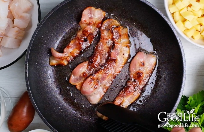 cooking the bacon in a deep saucepan