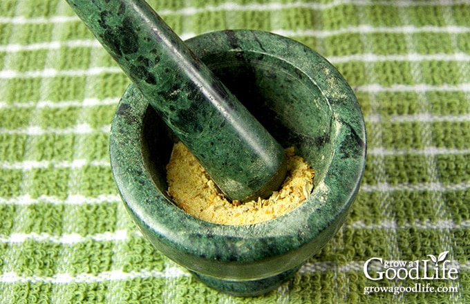 image of dried garlic in a green mortar and pestle a