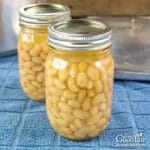 two jars of canned beans on a blue towel