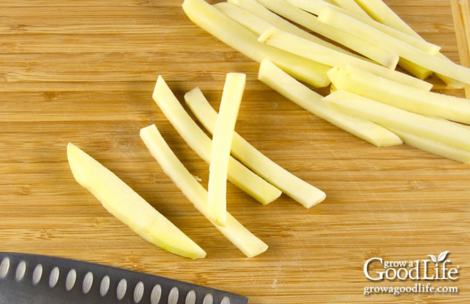 cutting potatoes into shoestring French fry shapes