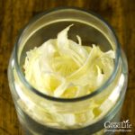overhead photo of dried onion flakes in a jar