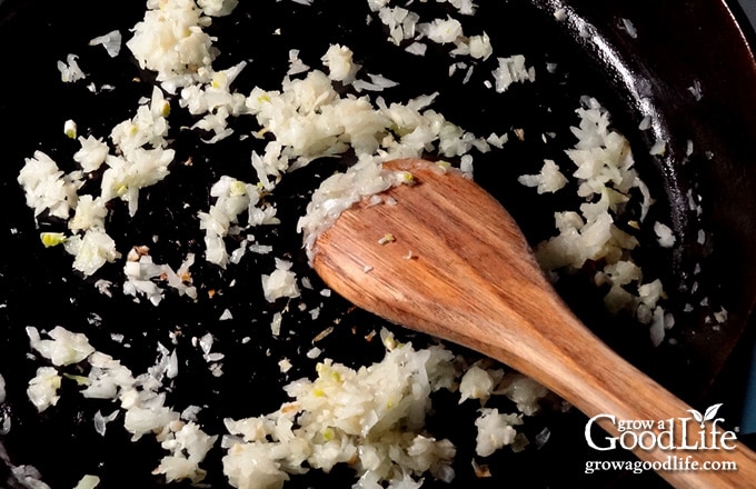 First, sauté the onions and garlic in a large skillet until fragrant and translucent, then add them to your slow cooker crock.