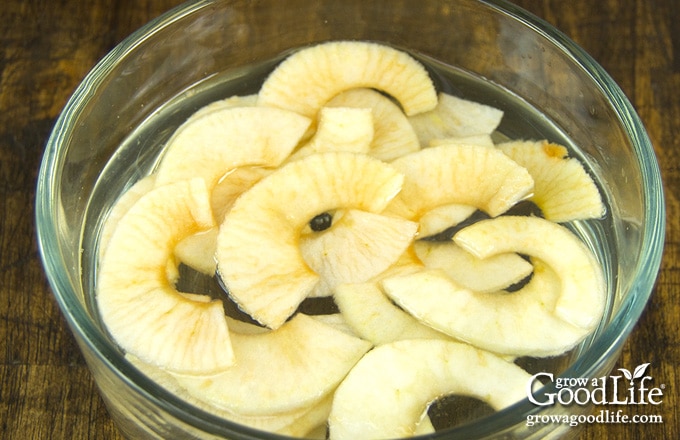 bowl of apple slices in pre-treating liquid