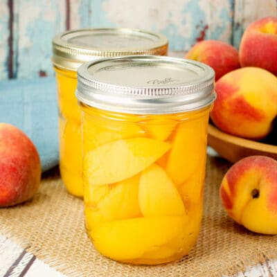 two jars of canned peaches on a table