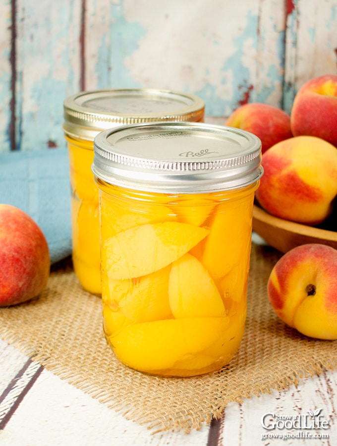 two jars of canned peaches on a table