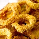 closeup photo of a pile of baked onion rings on a table