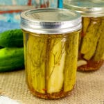 two jars of dill pickles on a table