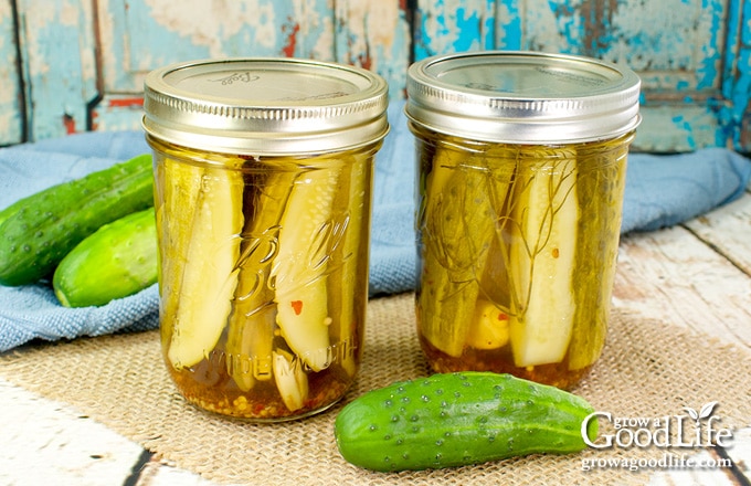 two jars of pickles on a white table