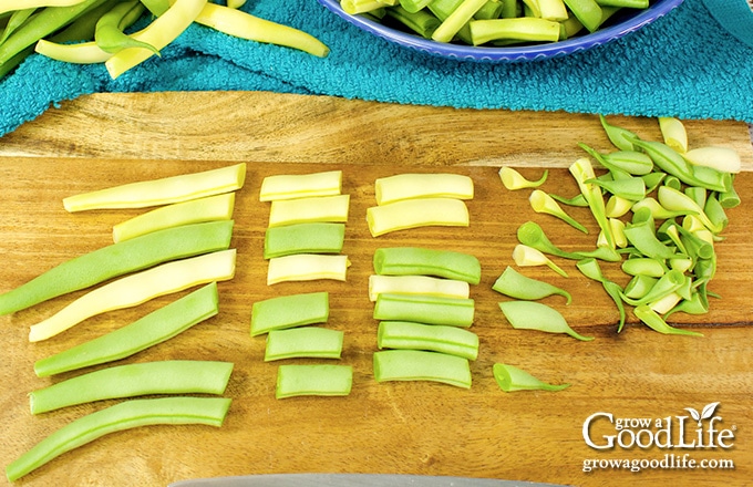 cut green and yellow string beans on a brown cutting board