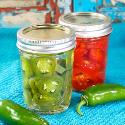 two jars of pickled jalapeños on a blue towel