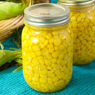 jars of canned corn on a blue towel