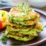 a stack of zucchini fritters on a brown plate