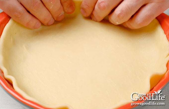 Lining the pie dish with the pie pastry.