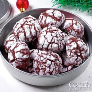 A silver cookie tin filled with homemade chocolate crinkle cookies.