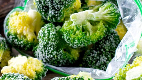 image of frozen broccoli in a freezer bag and scattered on a table