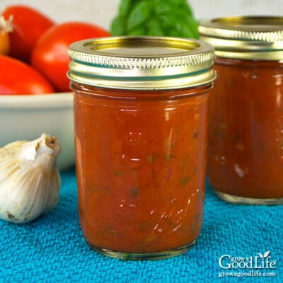 jars of home canned pizza sauce on a blue towel