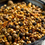 close up photo of homemade pickling spice mix in a black bowl