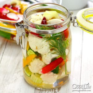 jar of mixed vegetables and pickling brine on a table