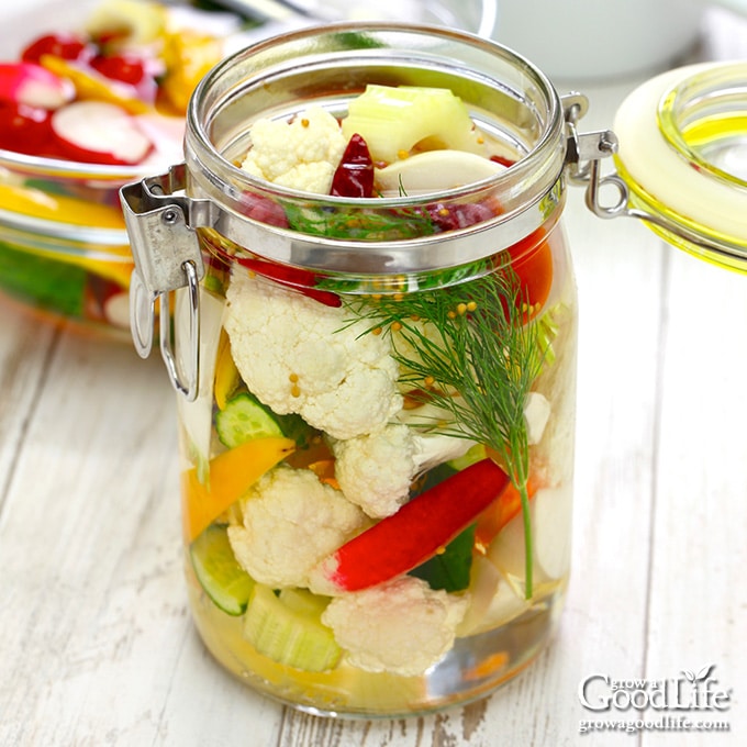jar of mixed vegetables and pickling brine on a table