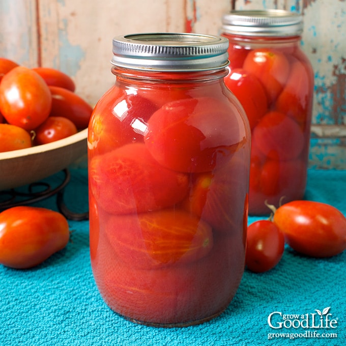 quart jars of canned whole tomatoes on a table