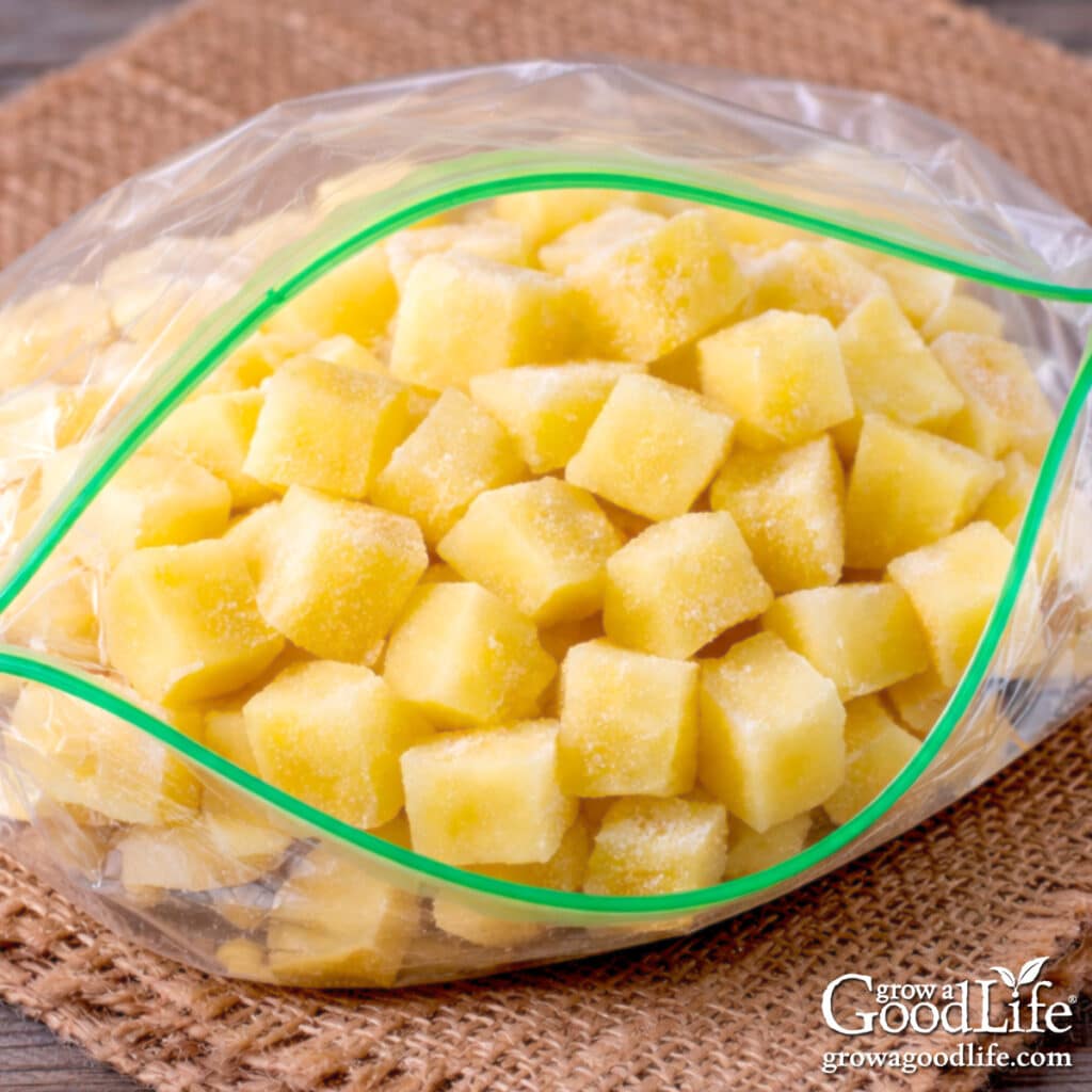Frozen cubed potatoes in an open freezer bag ready for storage.