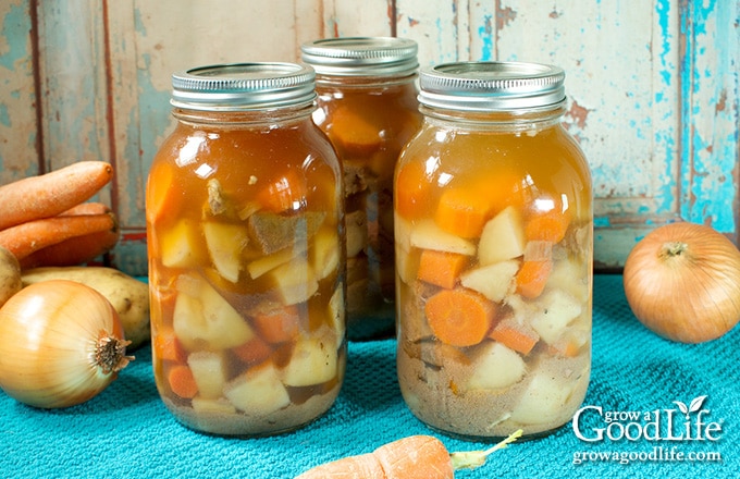 quart jars of canned beef stew on a blue towel