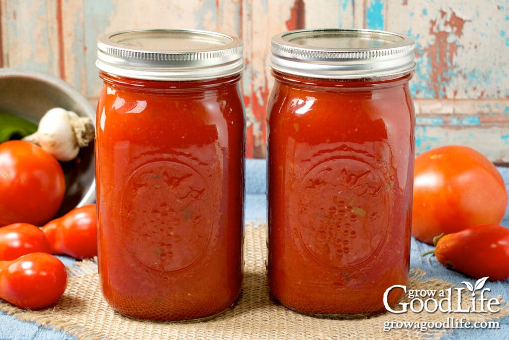 Jars of home canned spaghetti sauce on a table after pressure canning.