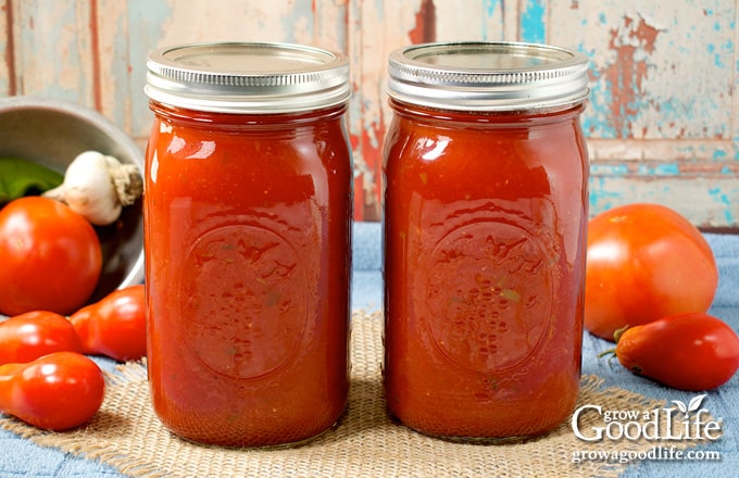 Home canned jars of spaghetti sauce on a table.