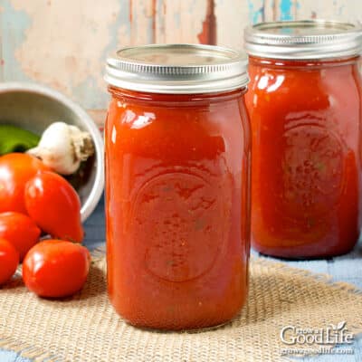 Quart jars of home canned spaghetti sauce on a table.