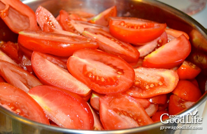 A pot filled with quartered tomatoes to make sauce.