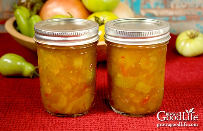 Jars of home-canned green tomato piccalilli on a table.