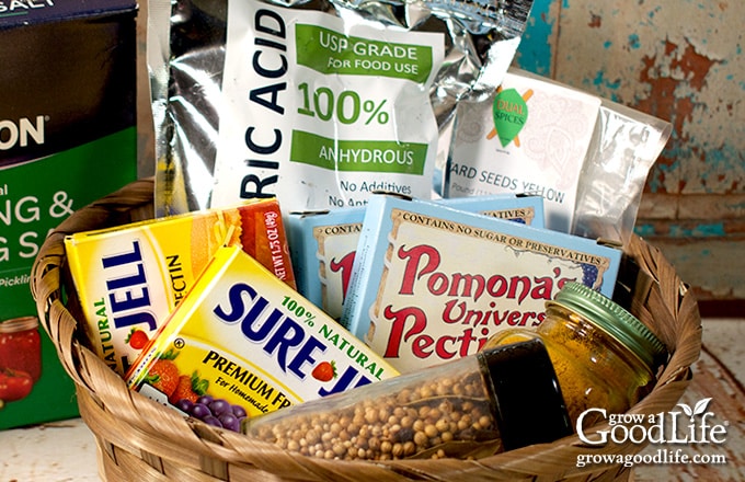 boxes of pectin, canning salt, pickling spices and other canning ingredients in a basket