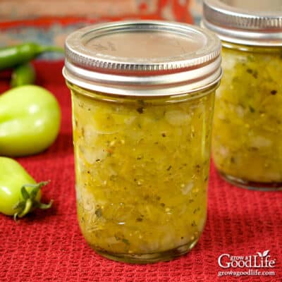 Jars of home-canned green tomato salsa on a table.