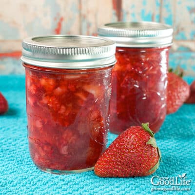Jars of homemade strawberry jam on a table.