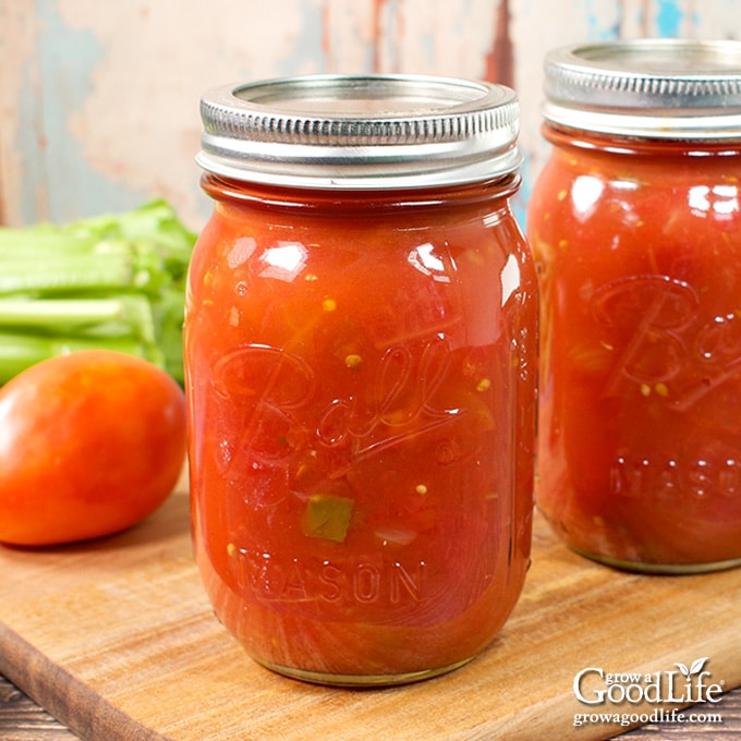 Jars of home canned stewed tomatoes on a table.