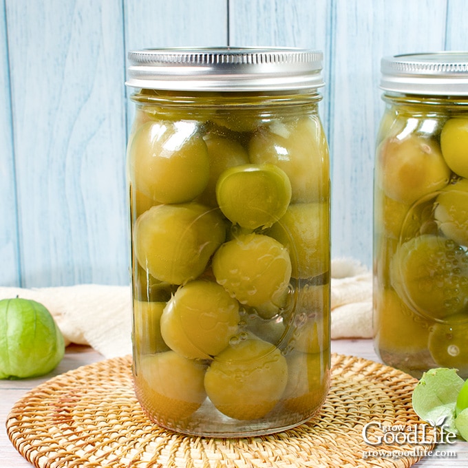 Jar of home canned tomatillos on a table.