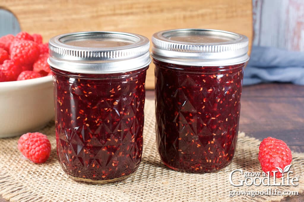 Jars of low sugar raspberry jam made with Pomona's pectin on a table.